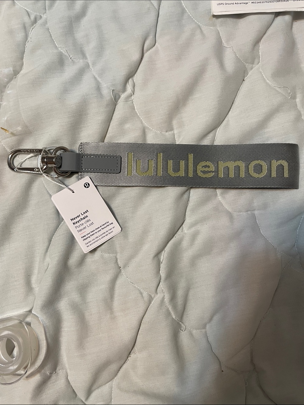 lululemon gray wristlet keychain with yellow-green logo